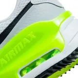 Championes Nike Air Max Systm de diseño deportivo, color blanco con detalles en gris claro, negro y verde neón. Presentan el logo de la marca en negro en el lateral y una unidad de aire visible en el talón con marco verde neón.