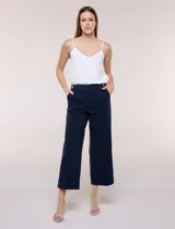 Pantalón crop azul marino de corte recto y estructurado, con cintura ancha, bolsillos laterales y botones decorativos en los laterales superiores. Presenta pinzas verticales frontales.