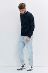 Pantalón de jean corte regular, color celeste claro, con diseño de cinco bolsillos y cierre frontal con botón y cremallera.