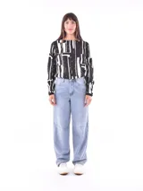 Blusa de mangas largas con estampado de hojas en tonos celeste y azul marino, con lazo en la cintura.