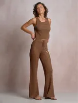Top crop de tejido calado marrón, marca Elan, con escote redondo, sin mangas y aberturas laterales con lazos ajustables decorados con caracoles.