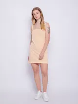 Vestido corto sin mangas de tela texturada color amarillo con lunares blancos y tirantes anchos.