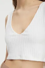 Crop top blanco de morley con lúrex, escote en V, de fit entallado y hombros anchos.