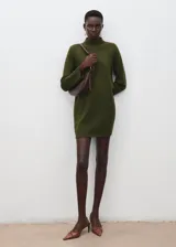 Vestido corto de punto color verde militar, con cuello alto, mangas largas y detalle de botones dorados en el hombro.