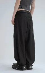 Pantalón negro de corte ancho y tiro alto, con múltiples bolsillos cargo y ajuste en los tobillos. Se lleva con un cinturón negro con hebilla metálica.