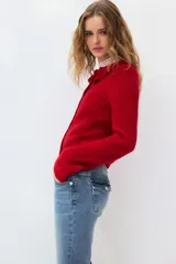 Jean de denim elástico color celeste claro, de tiro bajo y corte acampanado desde la rodilla. Cuenta con bolsillos abiertos delanteros, bolsillos traseros con solapa y botón, y cierre frontal con cremallera y botón metálico.