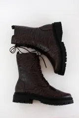 Borcego acordonado de cuero con textura croco, suela track de goma y cierre lateral interno. Incluye cordones intercambiables.