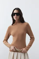 Polera de manga larga y cuello alto, confeccionada en tejido de punto fino, con un ajuste ceñido al cuerpo.