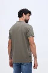 Chomba piqué de manga corta verde militar con cuello y puños tejidos a contratono en tonos claros. Cuenta con cartera de tres botones y pequeño logo bordado en el pecho.
