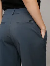 Pantalón de vestir azul petróleo, de corte sastre y pierna ancha. Presenta bolsillos laterales, cierre con clip y cremallera. Confeccionado en poliéster reciclado, ecovero viscosa y elastano.