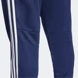 Pantalón deportivo Adidas Tiro 25 Essentials, color azul marino, con corte clásico y puños ajustados. Presenta las tres franjas características de Adidas en blanco a lo largo de las costuras laterales y el logo de la marca en blanco en el muslo.
