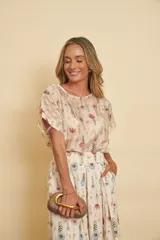 Pollera midi de algodón con estampado floral en tonos pasteles, diseño cruzado con pinzas y elástico en la parte posterior de la cintura.