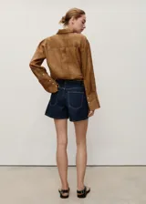 Short de jean de tiro alto con diseño recto, cinco bolsillos, cierre frontal con cremallera y botón, y trabillas para cinturón.