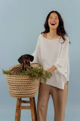 Buzo de hilo de tejido abierto, color blanco, con cuello redondo amplio y mangas tres cuartos con terminación acampanada. Presenta un corte holgado y asimétrico con aberturas laterales.