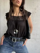 Musculosa negra con escote cuadrado con encaje y volados en los hombros.