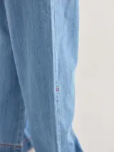 Pantalón de tiro medio alto, color beige, con bolsillos delanteros y traseros. Presenta detalles de atraques y triples costuras en color amarillo. Confeccionado en una mezcla de lino, algodón y viscosa.