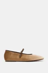 Zapato tipo bailarina de efecto terciopelo en color tostado, con tira fina ajustable con hebilla en el empeine y punta redonda.