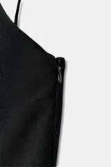 Mono corto amarillo pastel con escote redondo, tirantes finos ajustables y abertura frontal con solapa. Presenta cierre lateral oculto.