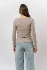 Remera de manga larga color beige, con escote redondo levemente abierto y calce regular. Confeccionada en tejido suave, liviano y con leve elasticidad.