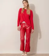 Pantalón de cuero rojo con diseño recto y aberturas en los tobillos.