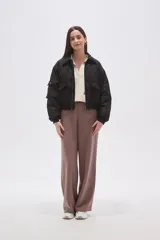 Campera tipo bomber color negro, con cierre frontal, cuello camisero, bolsillos frontales con solapa y puños elásticos.