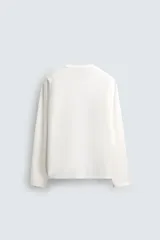 Camiseta de manga larga con corte relajado, confeccionada en tejido de algodón de peso medio, con cuello redondo acabado en rib.