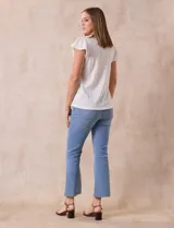 Blusa celeste en tejido pointelle con escote en V y mangas cortas con volados. Aplique de puntilla en el escote y en el frente.