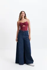 Top negro de tirantes finos con diseño de escote fruncido y abertura cut-out triangular en el centro del pecho. Confeccionado en tejido elástico, presenta un corte ajustado al cuerpo.