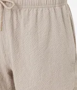 Bermuda playera masculina de corte básico, confeccionada en microfibra texturizada. Presenta cintura elástica con cordón ajustable y bolsillos laterales.