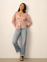 Cardigan de punto con estampado de mariposas en tonos rosados, cuello redondo, cierre frontal con botones y mangas tres cuartos.