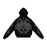 Hoodie con cierre frontal, color negro, con estampado gráfico de hojas de acanto en color blanco que recorre el frente y las mangas. Cuenta con bolsillos laterales y cierre metálico.