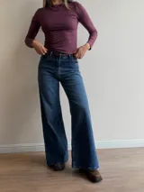 Pantalón de jean estilo wide leg con tiro alto, corte recto y amplio desde la cadera hasta el ruedo. Presenta un lavado azul clásico con sutiles detalles de textura.