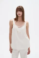 Musculosa blanca de viscosa con breteles anchos, cuello en V y detalle de lazo frontal.