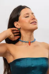 Collar corto de cuentas de cristal azules y verdes con un dije central en forma de cuerno de acrílico naranja.