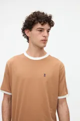Remera de manga corta azul con cuello redondo, puños y bandas en los hombros en color tostado. Presenta un pequeño bordado rojo en el pecho y está confeccionada en suave jersey de algodón con calce clásico.