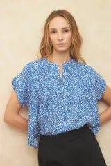 Blusa verde con estampado de hojas color salmón, cuello mao y mangas cortas.