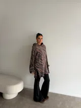 Canguro de viscosa con capucha, mangas largas abullonadas y diseño oversize con estampado animal print tipo cebra en tonos marrón y negro.