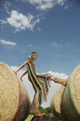 Vestido midi tejido al crochet con lurex, a rayas horizontales en tonos marrón, amarillo y negro, con terminación en flecos.