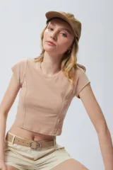 Top corto de manga corta, color negro con efecto desgastado o acid wash, cuello redondo y costuras verticales que definen la silueta.