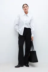 Camisa blanca de manga larga con puños abullonados y cuello clásico.