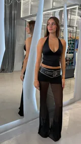 Pollera larga negra de tul, con corte amplio y tajo lateral. Presenta un forro corto que deja ver las piernas a través de la tela transparente.