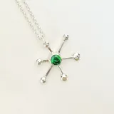 Collar con dije de pulpo plateado con piedra verde engarzada, con cadena de eslabones finos.