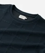 Buzo de cuello redondo y manga larga, confeccionado en tejido de poliéster con textura de cuerdas en relieve y puños acanalados.