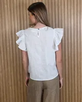 Musculosa de lino color marrón con mangas con volantes y cuello redondo.