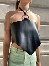 Top negro de ecocuero con corte irregular, cuello halter con argolla metálica y espalda ajustable.