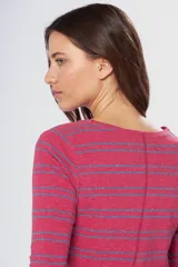 Remera de manga larga con cuello redondo, confeccionada en tejido rayado horizontal en tonos rojo y azul, con detalle de pin metálico con logo en la parte frontal.