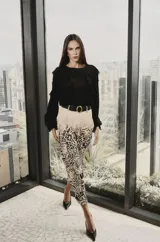 Camisa negra de manga larga con volados frontales y en las mangas, confeccionada en tela ligera y fluida.