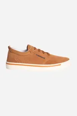 Zapatilla casual de cuero color camel, estilo skate o lona, con cordones marrones y suela de goma blanca con una línea naranja decorativa.