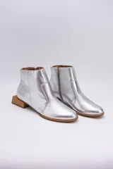 Botas cortas plateadas de cuero con cierre lateral y tacón bajo cuadrado de madera.