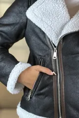 Campera tipo gamulán de cuero sintético negro con interior y solapas de corderito blanco. Presenta cierre frontal cruzado y bolsillos laterales con cierre.
